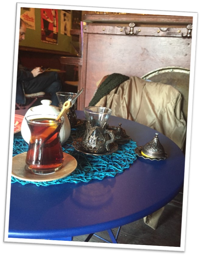 A teapot and two tea glasses on a café table.