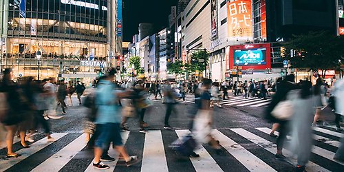 People crossing a Shibuya crosswalk in Tokyo, Japan in the night.