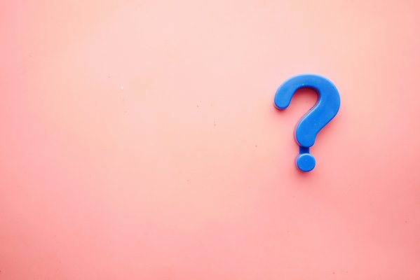 A blue question mark against a pink background.