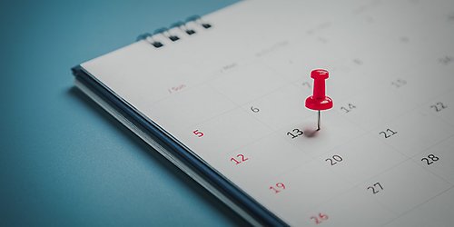 Röd knappnål fastsatt i kalender