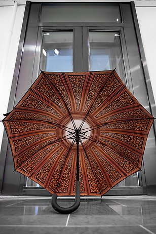 Ett utfällt paraply, står på golvet så att undersidan visas. 