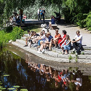 Studenter sitter vid ån i Gotlandsparken.